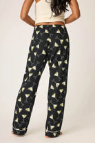 Person wearing black pants with martini glass pattern on a white background