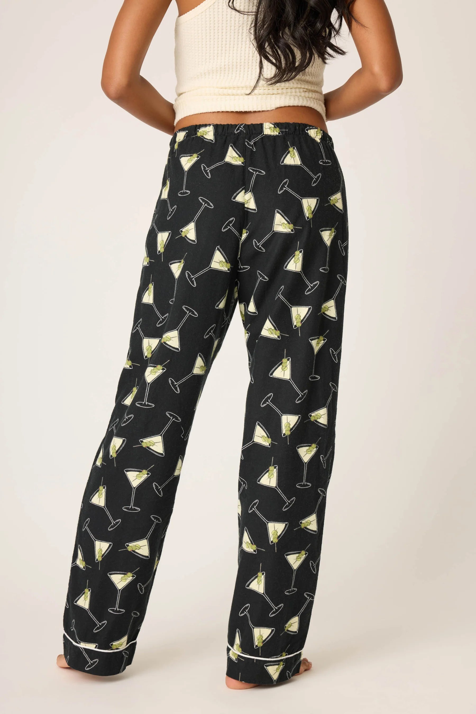 Person wearing black pants with martini glass pattern on a white background