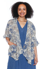 Woman wearing a floral short cardigan over a blue dress on a white background