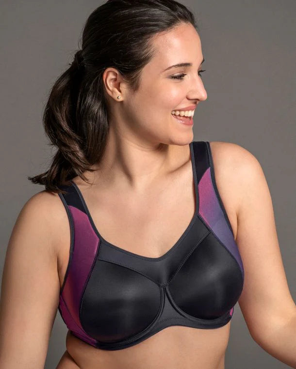 Woman wearing a black and purple sports bra against a gray background