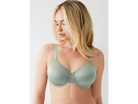 Woman wearing a green bra against a white background