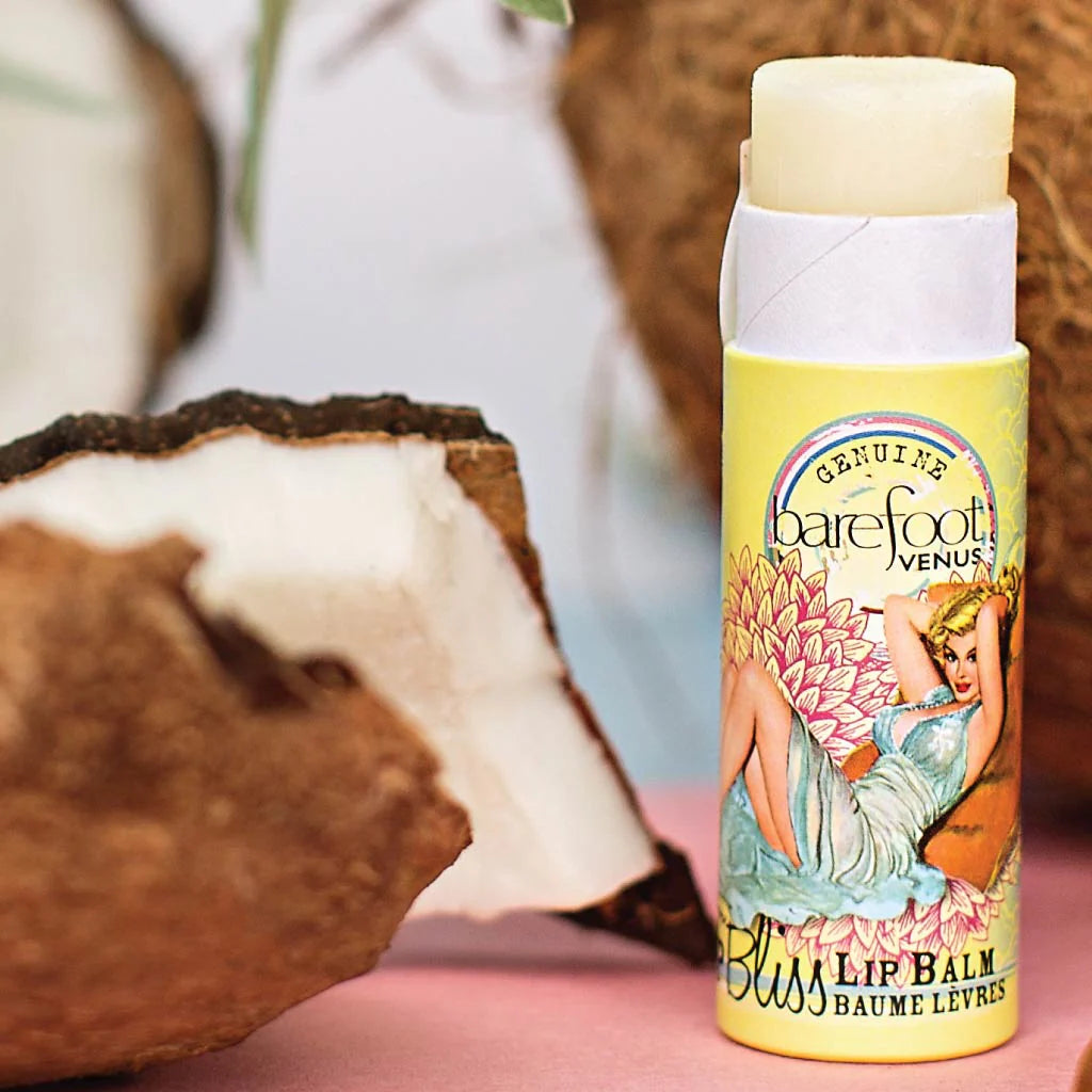 Barefoot Venus Lip Bliss lip balm tube in Coconut Kiss against a coconut background. 