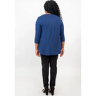 Blue Sky Jazz 3/4 Sleeve Top in Indigo shown on a model wearing black leggings standing against a white background, from the back view. 