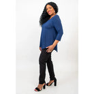 Blue Sky Jazz 3/4 Sleeve Top in Indigo shown on a model wearing black leggings standing against a white background, from the side view. 