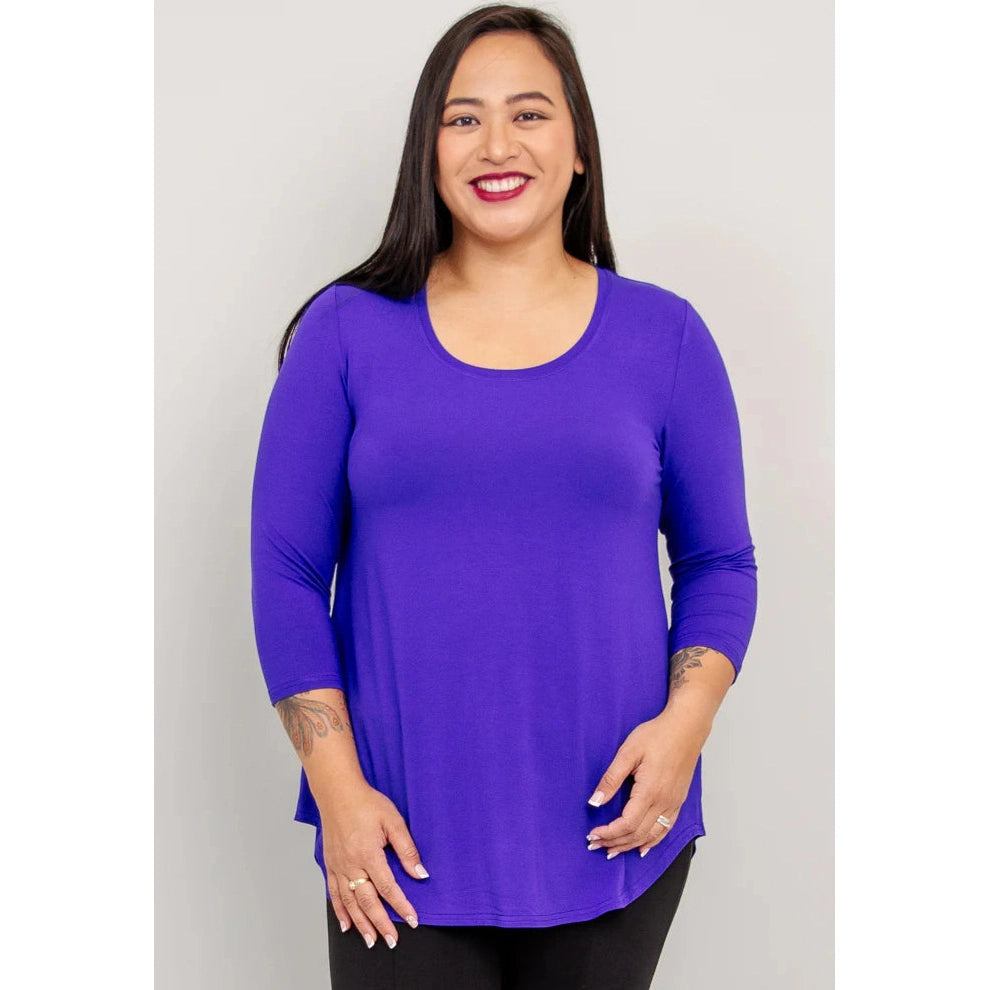 Blue Sky Jazz 3/4 Sleeve Top in Violet Blue shown on a model with black leggings standing against a white background, shown from the front view. 