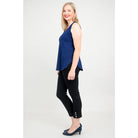 Blue Sky Jazz Tank in Indigo shown on a model wearing black leggings standing against a white background, from the side view. 