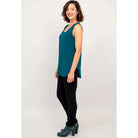 Blue Sky Jazz Tank in Teal shown on a model wearing black leggings against a white background, from the side view. 