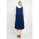 Blue Sky Juni Dress in Indigo shown on a model against a white background, from the back view. 