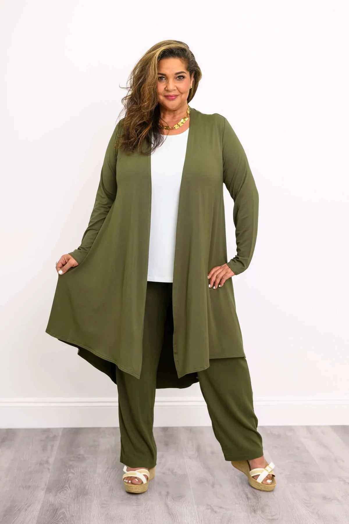 Blue Sky Priscilla Jacket in Khaki shown on a model wearing a white tank and khaki pants, standing against a white background, from the front view. 