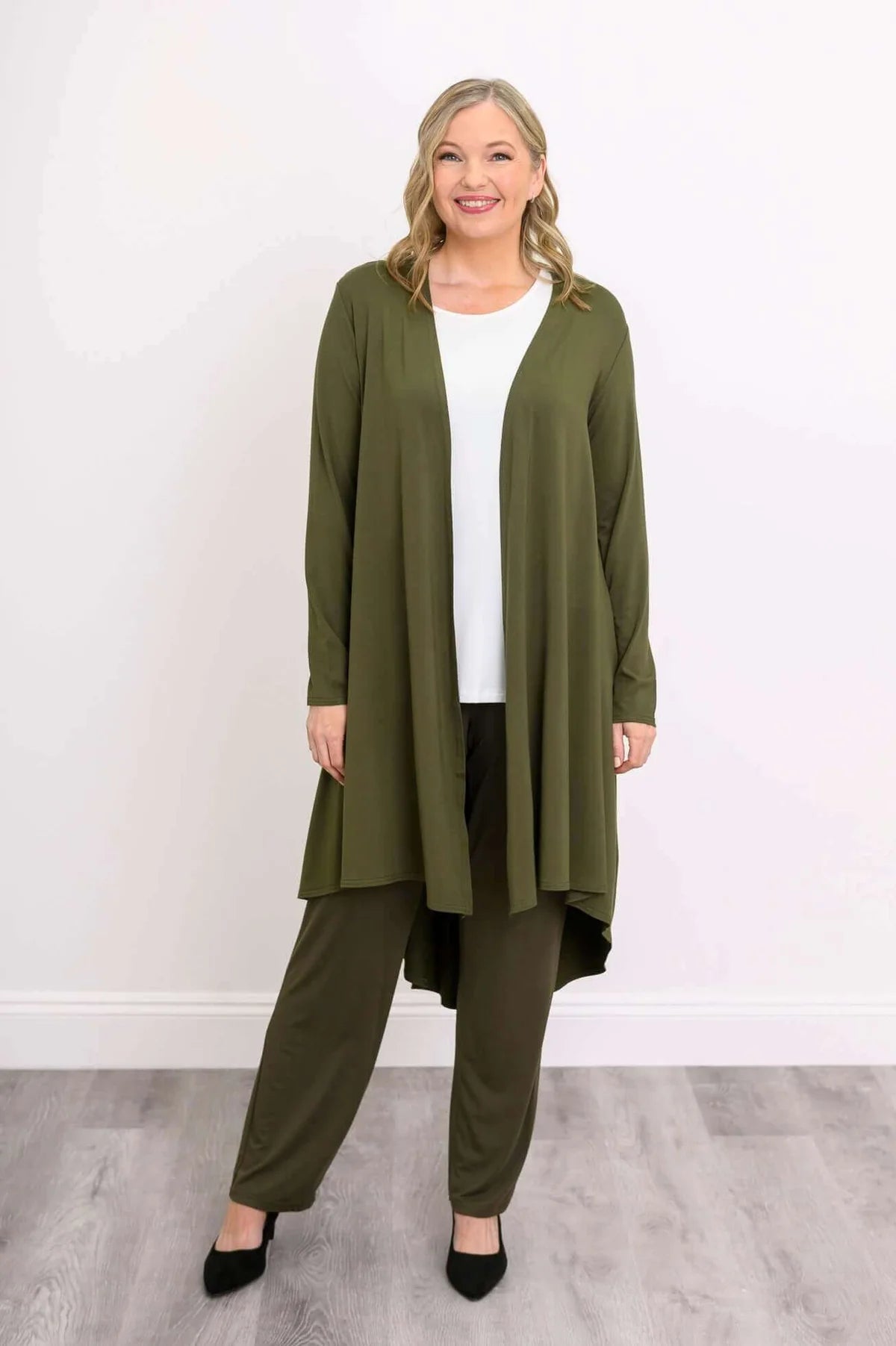Blue Sky Priscilla Jacket in Khaki shown on a model wearing a white tank and khaki pants, standing against a white background, from the front view. 