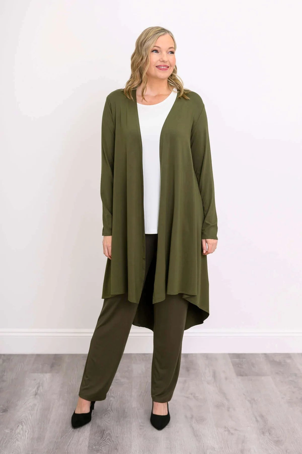 Blue Sky Priscilla Jacket in Khaki shown on a model wearing a white tank and khaki pants, standing against a white background, from the front view. 