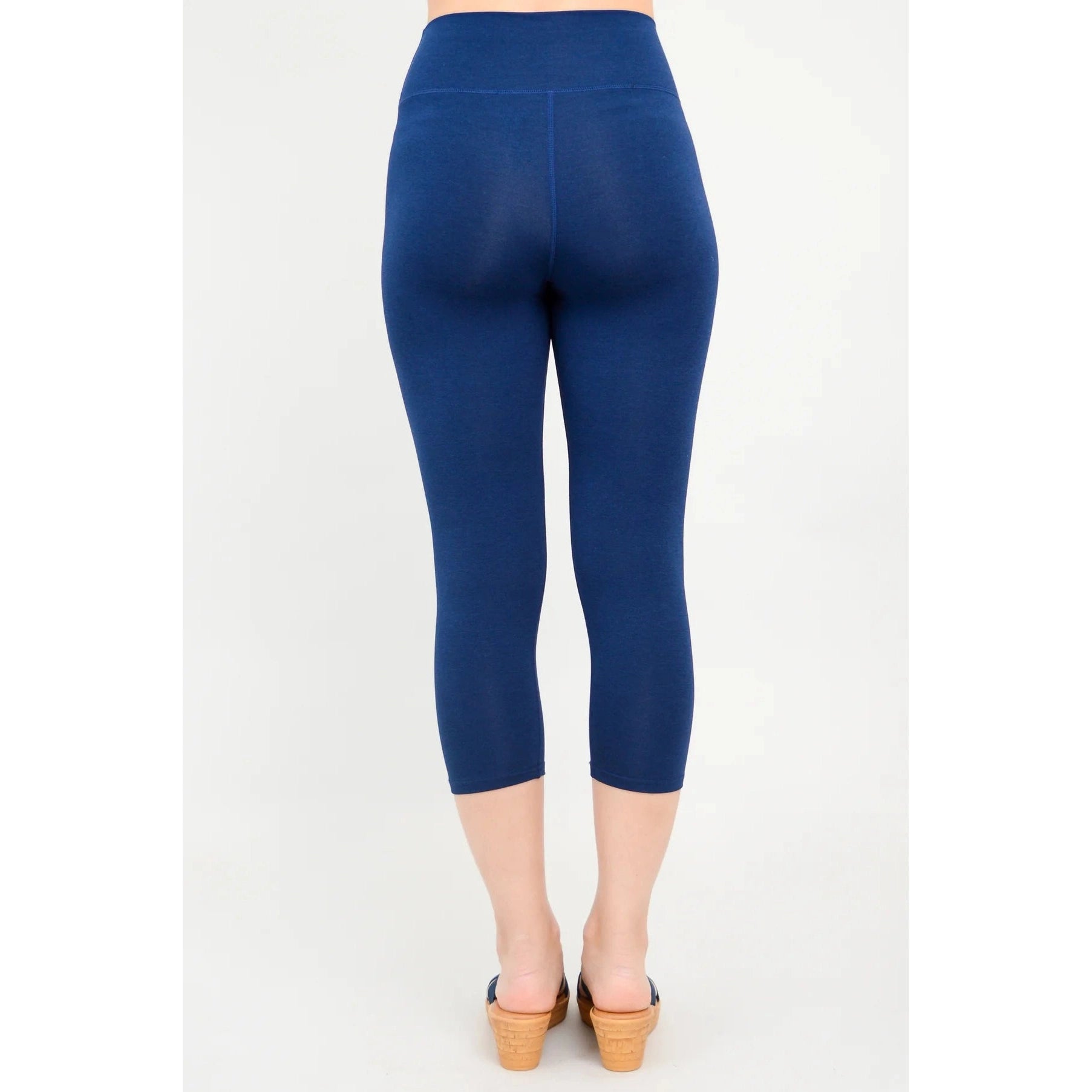 Blue Sky Riley Capris in Indigo shown on a model against a white background, from the back view. 