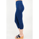 Blue Sky Riley Capris in Indigo shown on a model against a white background, from the side view. 