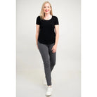 Blue Sky Tessa Tee in Black shown on a model wearing grey leggings standing against a white background, from the front view. 