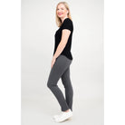 Blue Sky Tessa Tee in Black shown on a model wearing grey leggings standing against a white background, from the side view. 
