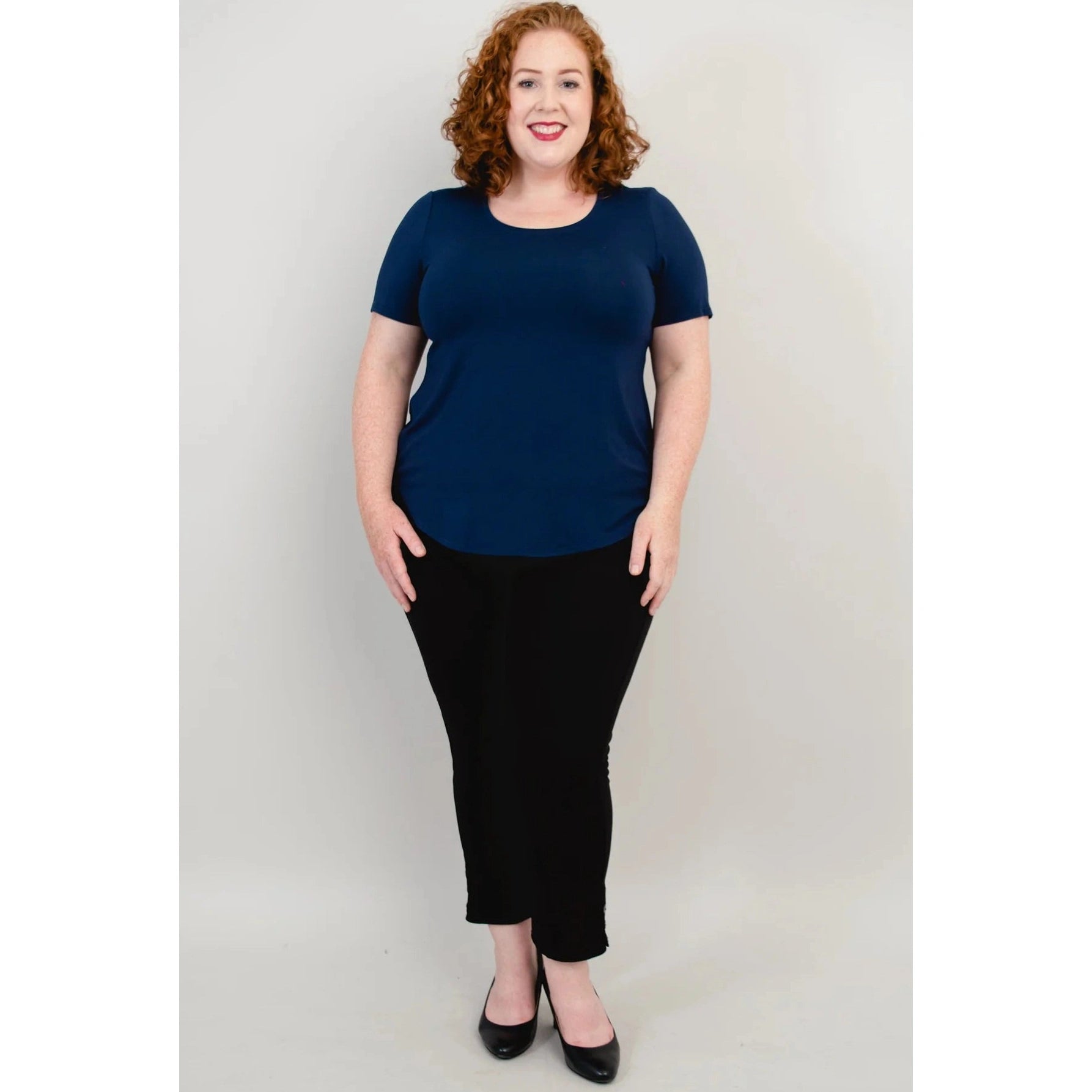 Blue Sky Tessa Tee in Indigo shown on a model wearing black leggings standing against a white background, from the front view. 