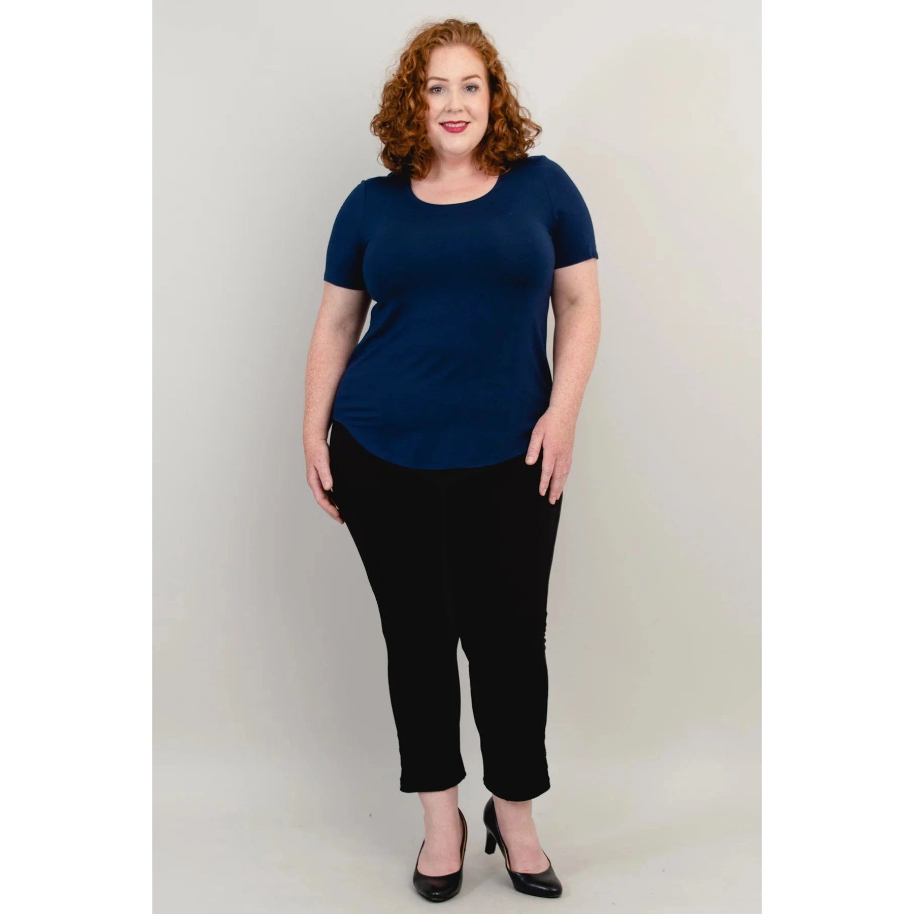Blue Sky Tessa Tee in Indigo shown on a model wearing black leggings standing against a white background, from the front view. 