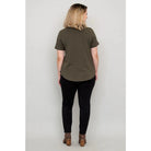 Blue Sky Tessa Tee in Khaki shown on a model wearing black leggings against a white background, from the back view. 