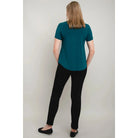 Blue Sky Tessa Tee in Teal shown on a model wearing black leggings against a white background, from the back view. 
