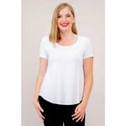 Blue Sky Tessa Tee in white shown on a model wearing black leggings, standing against a white background, from the front view. 