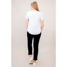 Blue Sky Tessa Tee in white shown on a model wearing black leggings, standing against a white background, from the back view. 