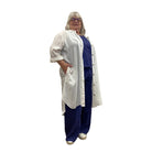Woman wearing the Escape Getaway dress, a white button-down worn open over a navy tank and pants. 