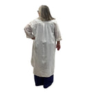 Woman wearing the Escape Getaway dress, a white button-down worn open over a navy tank and pants. 