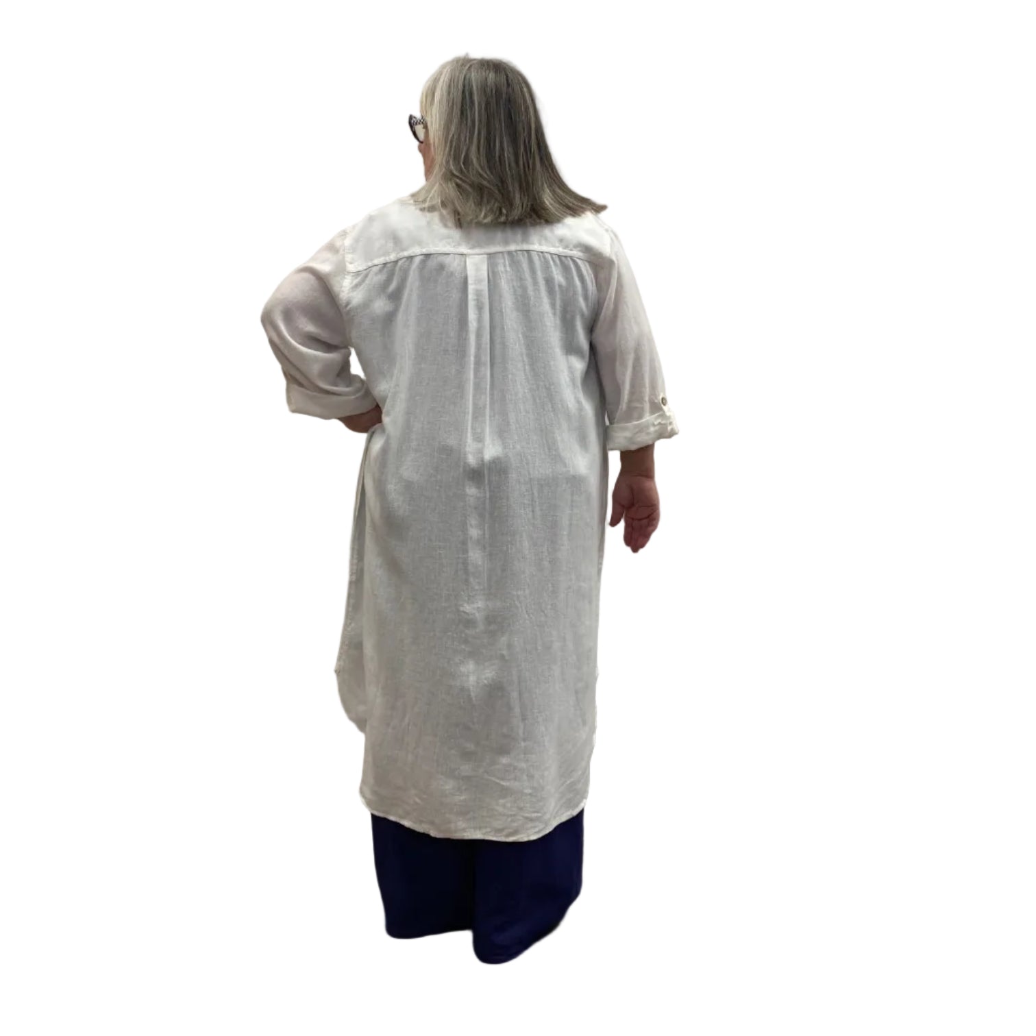 Woman wearing the Escape Getaway dress, a white button-down worn open over a navy tank and pants. 