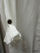 Close-up of a white shirt with a button on a light gray background