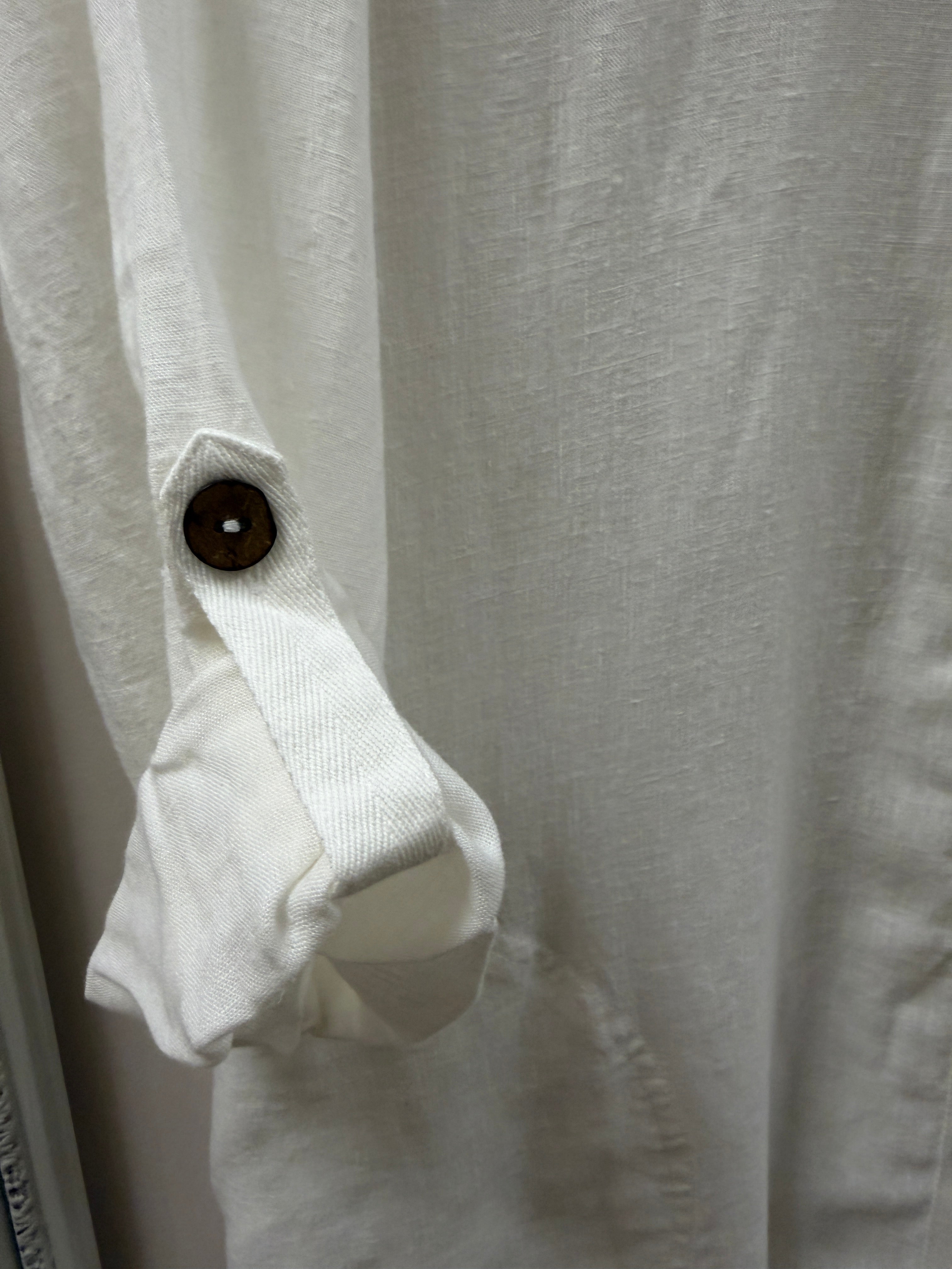 Close-up of a white shirt with a button on a light gray background