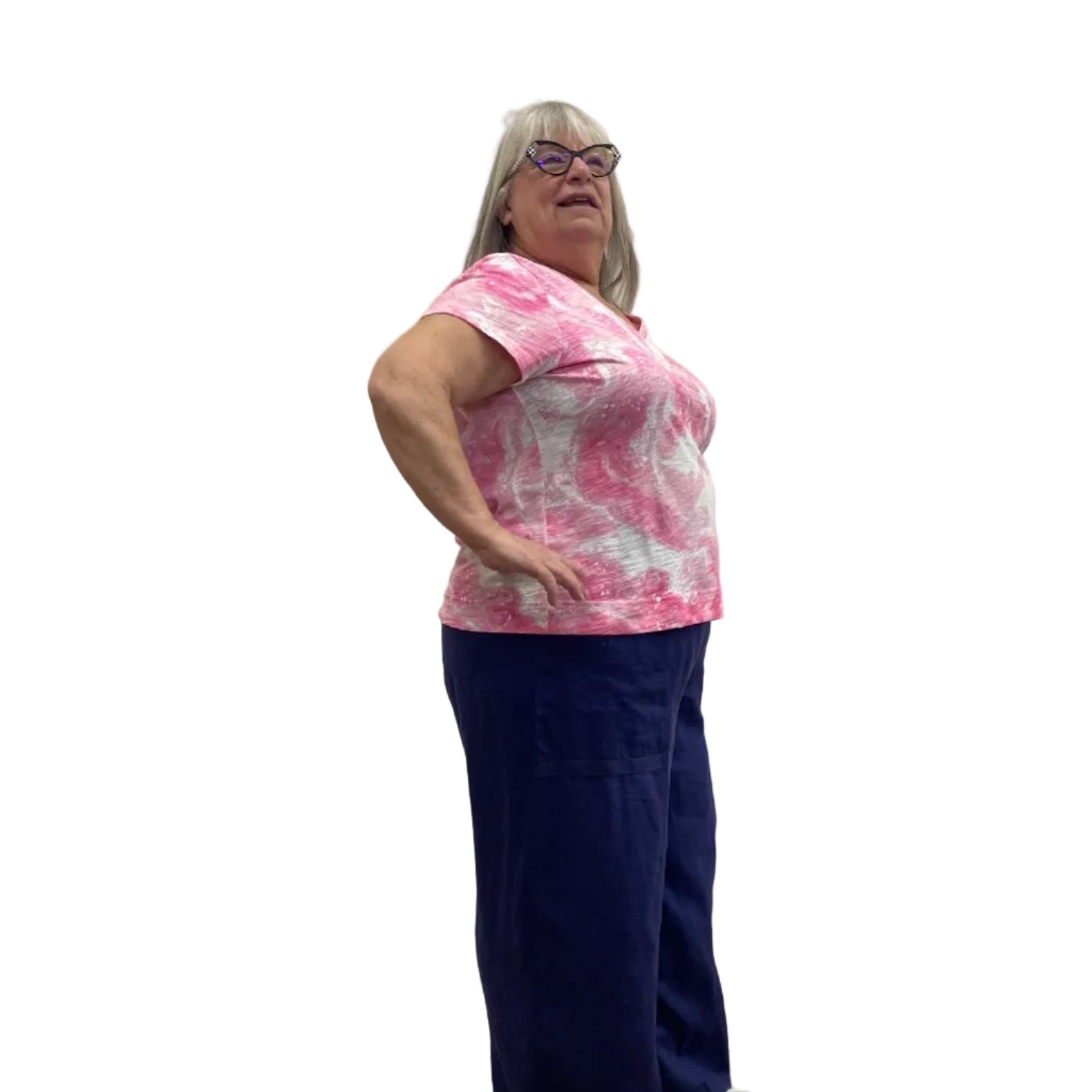 Woman wearing the Escape V Neck Tee in Cosmo pink and white paired with a navy pant against a white background. 