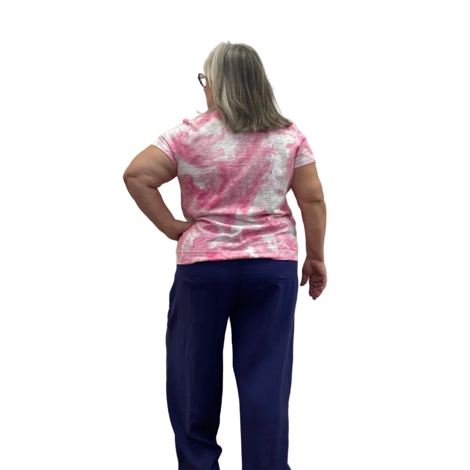 Woman wearing the Escape V Neck Tee in Cosmo pink and white paired with a navy pant against a white background. 