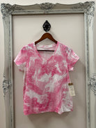 Pink and white tie-dye dress on a hanger with a decorative frame in the background