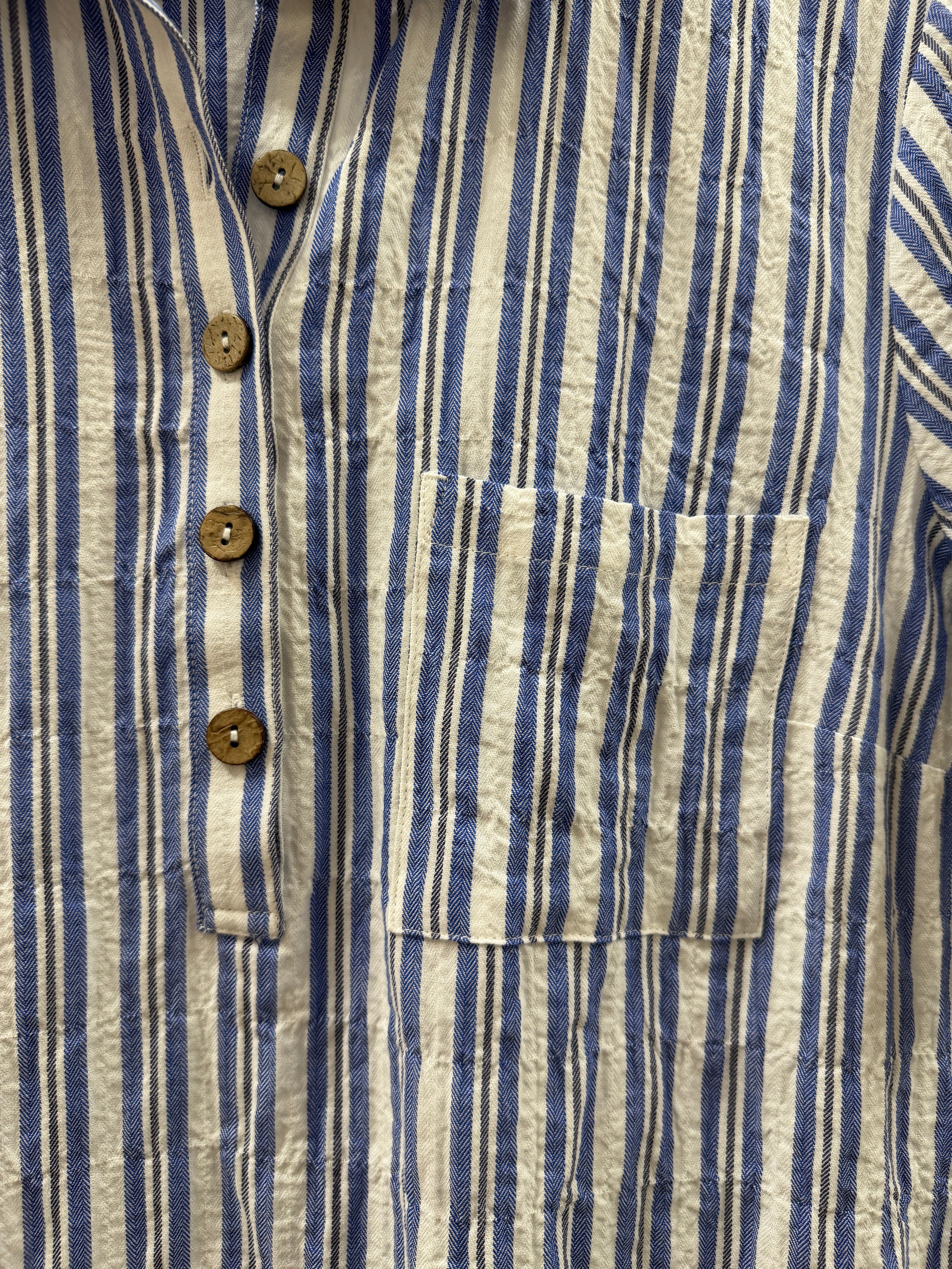 Close-up of a blue and white striped shirt with button details
