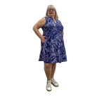 Woman wearing a Escape Paradise Dress in navy and white floral pattern against a white background. 