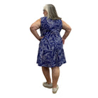 Woman wearing a Escape Paradise Dress in navy and white floral pattern against a white background. 