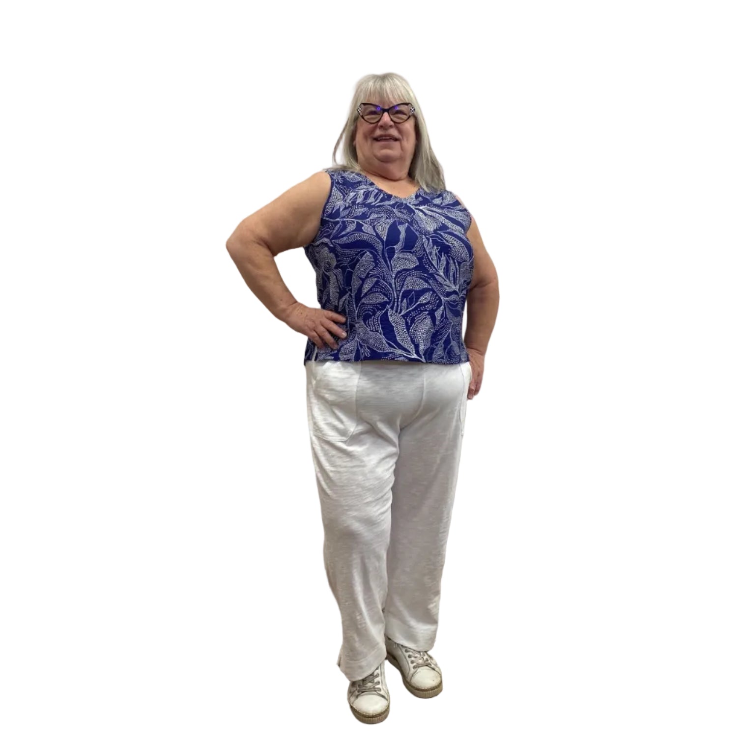 Woman wearing Escape Pocket Trousers in white, paired with a navy and white floral tank, against a white background. 