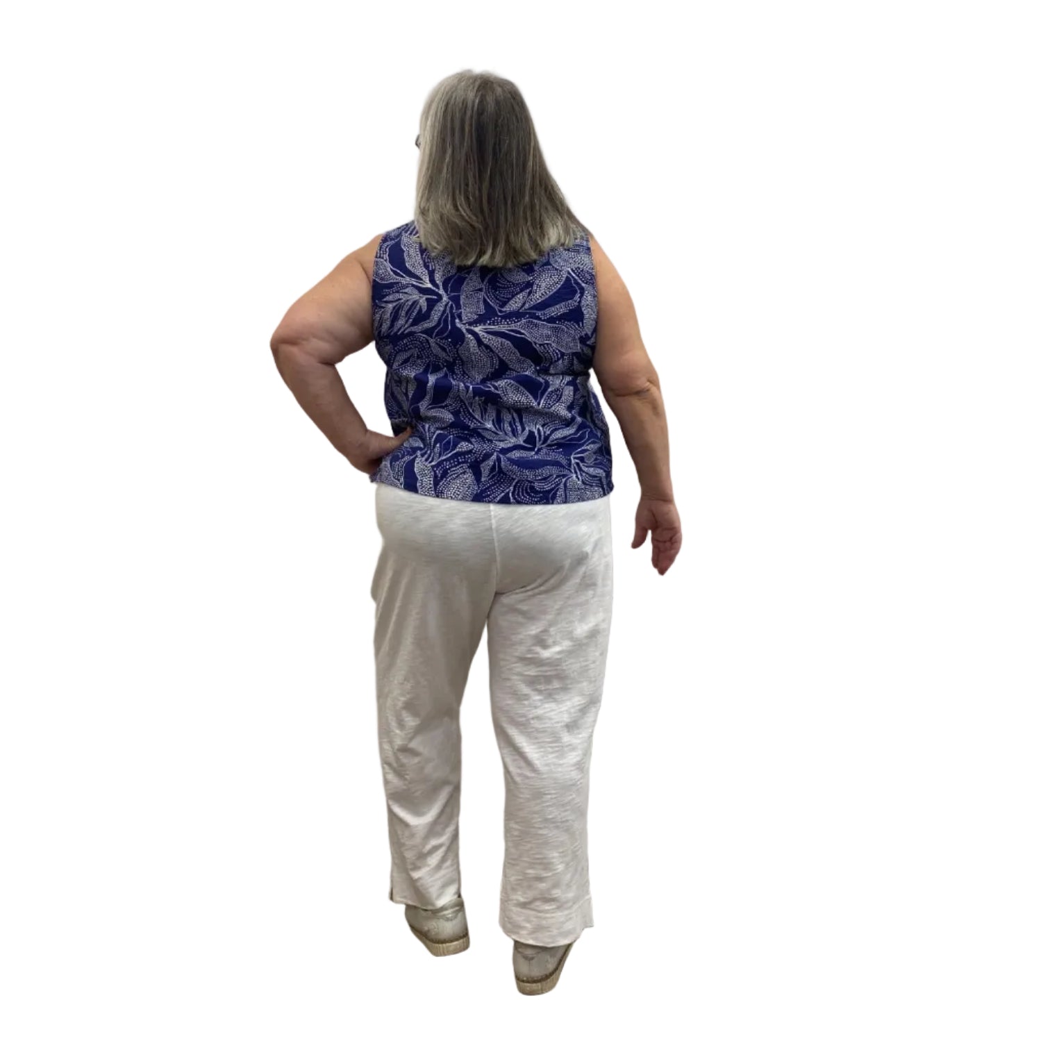 Woman wearing Escape Pocket Trousers in white, paired with a navy and white floral tank, against a white background. 