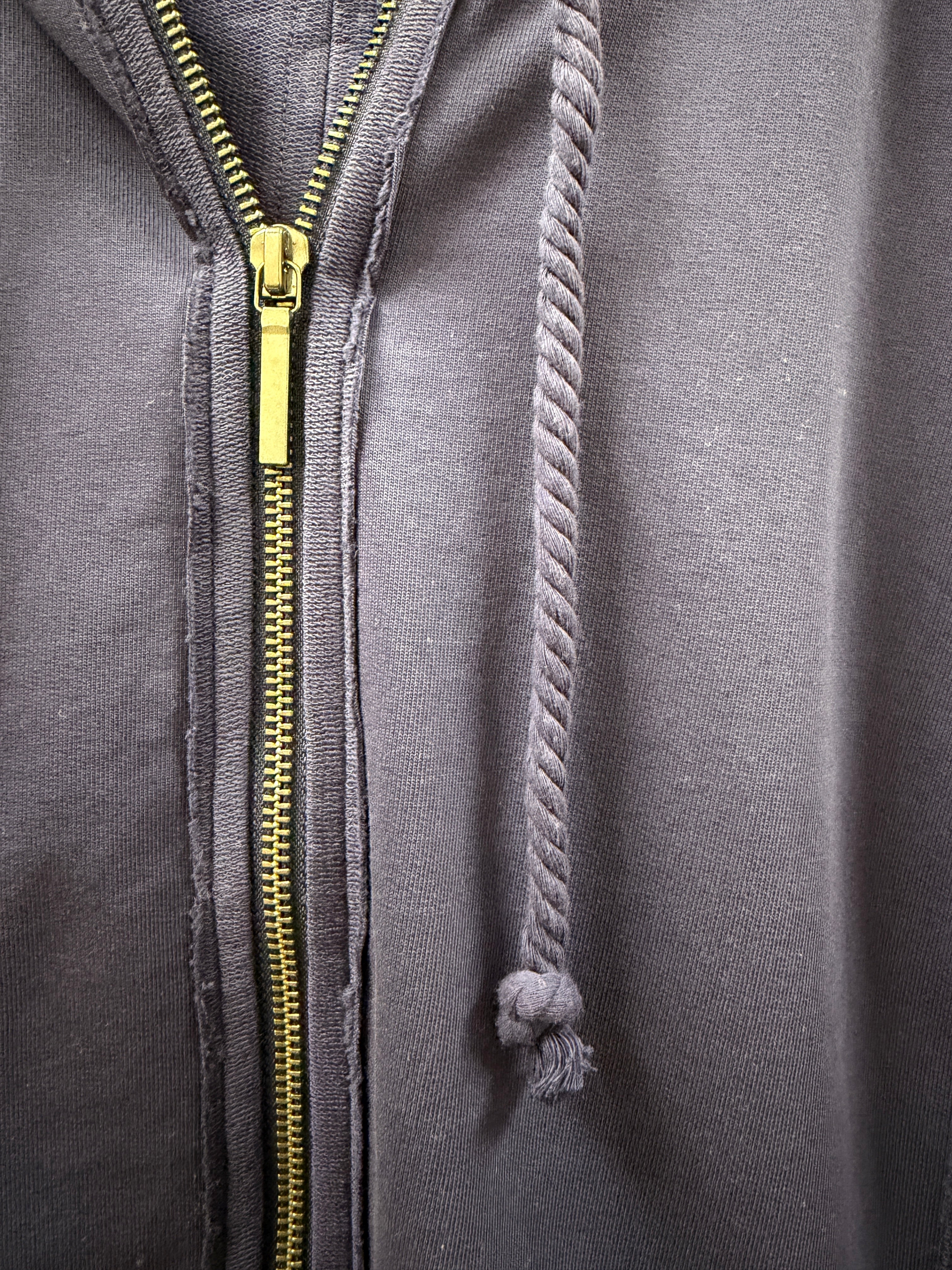 Close-up of a navy hoodie with a gold zipper