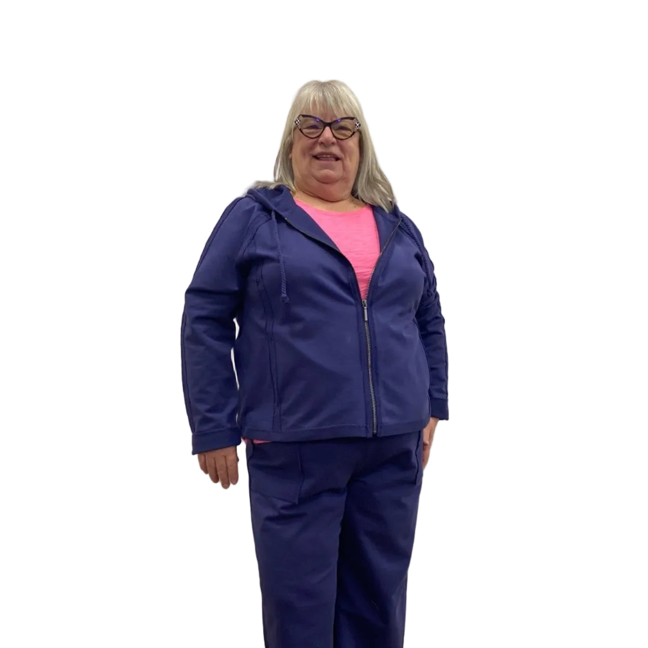 Woman wearing a navy zip up Escape Solstice Hoodie over a pink shirt and with navy pants on a white background. 