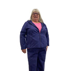 Woman wearing a navy zip up Escape Solstice Hoodie over a pink shirt and with navy pants on a white background. 