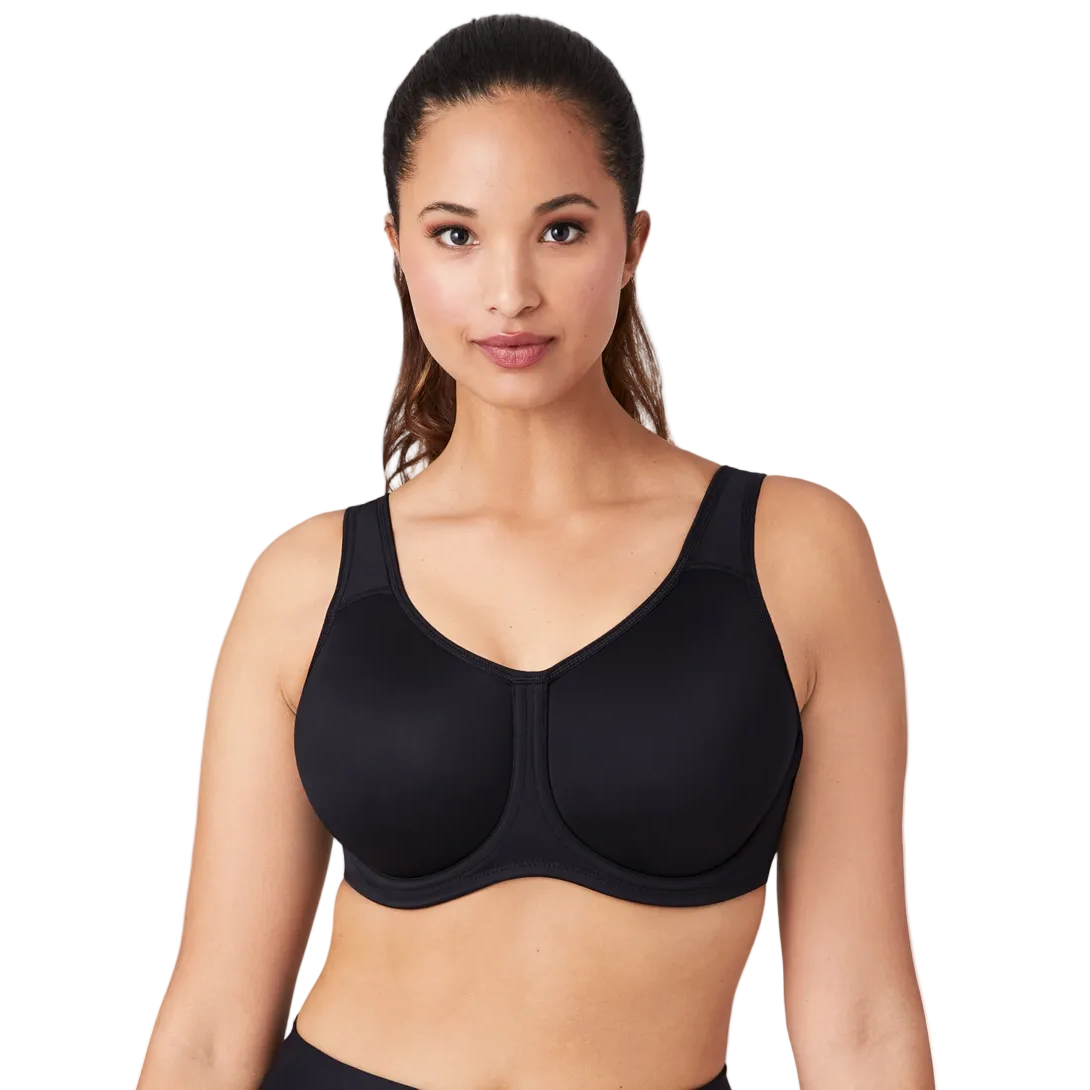 Woman wearing a black Wacoal Simone Underwired Sports bra on a white background